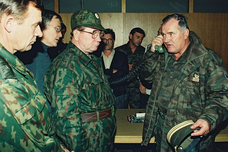 ARCHIVO - El general serbobosnio Ratko Mladic, derecha, habla por teléfono junto al general del ejército ruso, Vladimir Zurbenko, centro, durante la visita de una delegación de dicho organismo a la ciudad bosnia de Banja Luka, en octubre de1995. (AP Foto/Radivoje Pavicic, Archivo)