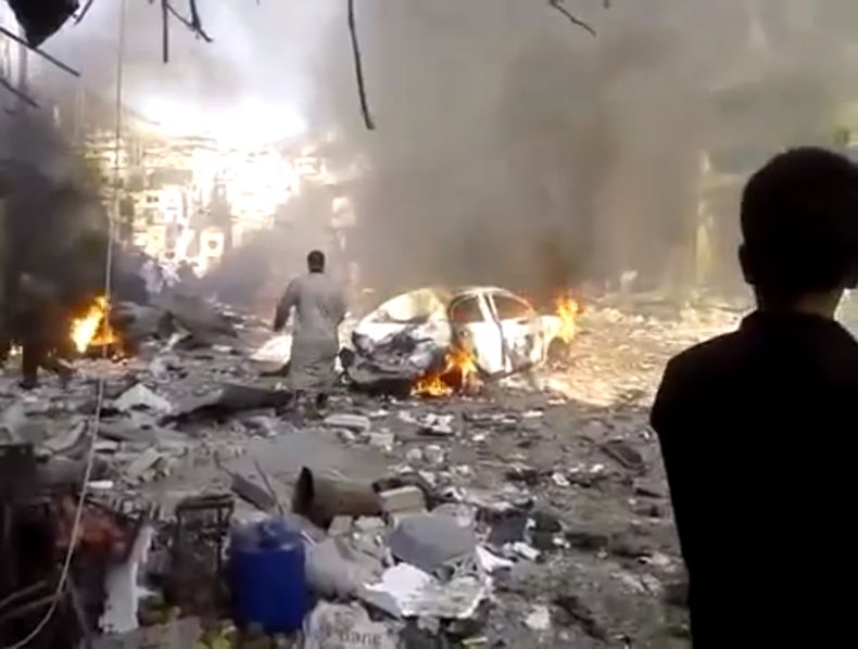 Lugar donde estall&oacute; un carro bomba en un mercado en el poblado de Darkoush, en la provincia de Idlib, Siria, el lunes 14 de octubre de 2013, en una imagen tomada de un video de un ciudadano y colgada por la Shaam News Network, que es similar a otro