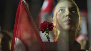 Una manifestante sostiene una flor detrás de la barrera policial durante una protesta por el arresto del alcalde de Estambul, Ekrem Imamoglu, en Estambul, Turquía, el martes 25 de marzo de 2025. (AP Foto/Francisco Seco)