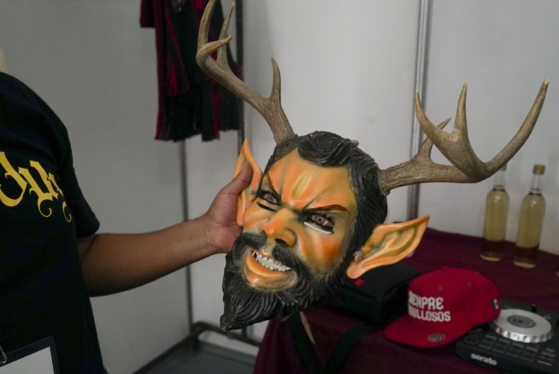 El artista mexicano-triqui Carlos CGH sostiene una máscara usada durante El Baile del Diablo, un baile tradicional de la costa de Oaxaca, tras bambalinas previo a su actuación en una celebración de los pueblos indígenas, en el Zócalo de la Ciudad de México, el martes 6 de agosto de 2024. (Foto AP/Mariana Martínez Barba)