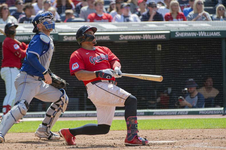 Josh Naylor, derecha, de los Guardianes de Cleveland, observa el vuelo de la pelota de su cuadrangular solitario frente al relevista de los Azulejos de Toronto, Brendon Little, durante la cuarta entrada del juego de béisbol, el domingo 23 de junio de 2024, en Cleveland. (AP Foto/Phil Long)