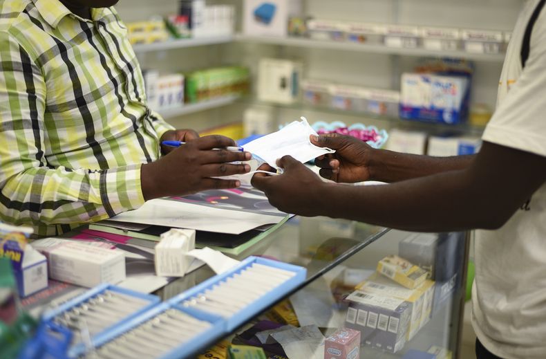 Un hombre compra una mascarilla en una farmacia en Kitwe, Zambia el 6 de febrero del 2020. (AP foto/Emmanuel Mwiche)