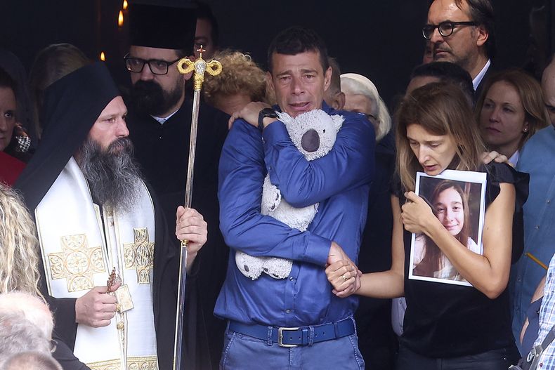 Los padres de una de las víctimas de una balacera en una escuela, Ema Kobiljski, de 13 años, lloran a su hija durante su entierro en el cementerio central de Belgrado, Serbia, el 6 de mayo de 2023. (AP Foto/Armin Durgut)