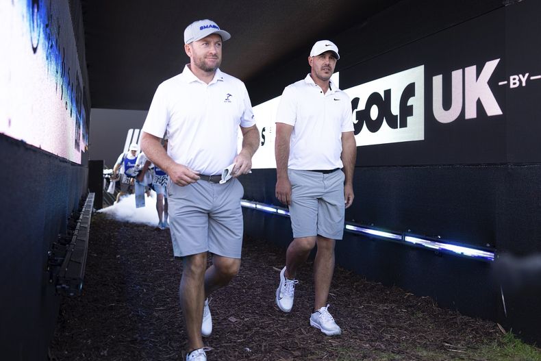 Graeme McDowell de Smash GC y el capitán Brooks Koepka de Smash GC caminan hacia el hoyo 14 durante la primera ronda de LIV Golf United Kingdom by JCB en JCB Golf & Country Club el viernes 26 de julio de 2024, en Rocester, Inglaterra. (Foto de Chris Trotman/LIV Golf vía AP)
