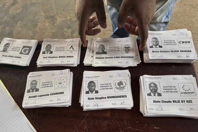 Las boletas con los nombres de los candidatos a la presidencia, sobre una mesa en un centro de votación en Liberville, Gabón, el 12 de abril de 2025. (AP Foto/Betines Makosso)