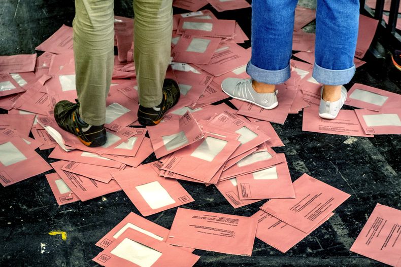 Sobre vacíos de votos por correo en las elecciones europeas se ven en el suelo en una sala durante el conteo electoral de las elecciones europeas, en Fráncfort, Alemania, el domingo 9 de junio de 2024. (AP Foto/Michael Probst)