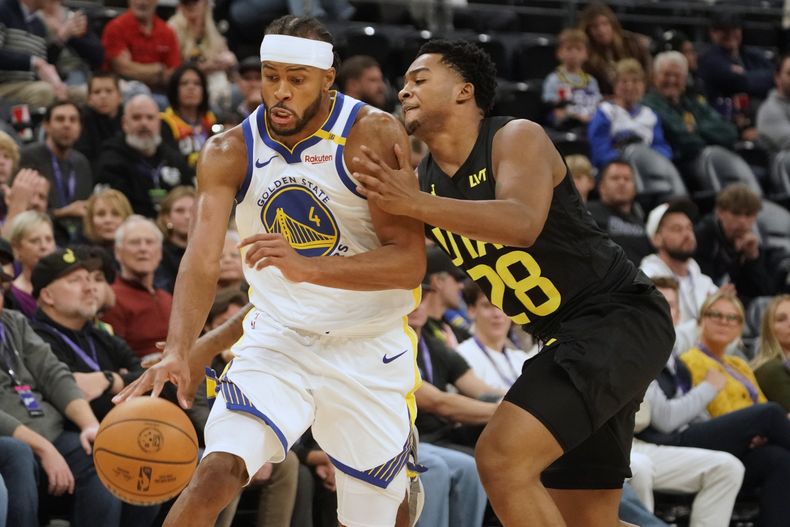 Brice Sensabaugh (28), del Jazz de Utah, roba el balón a Moses Moody (4), de los Warriors de Golden State en la segunda mitad del juego de baloncesto de la NBA, el viernes 25 de octubre de 2024, en Salt Lake City. (AP Foto/George Frey)