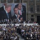 ARCHIVO - El presidente estadounidense Donald Trump --en la pantalla a la izquierda--, el mandatario francés Emmanuel Macron y el jefe de despacho de la Casa Blanca, Reince Priebus, --atrás a la derecha-- observan un desfile por el Día de la Bastilla sobre la avenida Campos Elíseos, el 14 de julio de 2017, en París. (AP Foto/Carolyn Kaster, archivo)