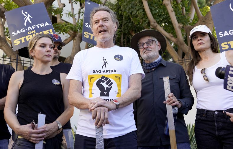 Rhea Seehorn, de izquierda a derecha, Bryan Cranston, el guionista Peter Gould y Betsy Brandt, de la serie Breaking Bad, hablan en un mitin frente a los estudios de Sony Pictures el martes 29 de agosto de 2023 en Culver City, California. Las industrias del cine y la televisión siguen paralizadas por las huelgas duales de actores y guionistas de Hollywood y sus efectos se sienten en otros sectores de la economía de Los Ángeles. (Foto AP/Chris Pizzello)
