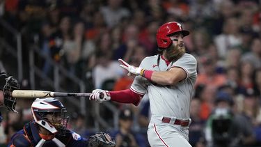 Brandon Marsh, derecha, de los Filis de Filadelfia, pega sencillo productor mientras el receptor de los Astros de Houston, Martin Maldonado, se queda esperando el lanzamiento durante la séptima entrada del juego de béisbol, el viernes 28 de abril de 2023, en Houston. (AP Foto/David J. Phillip)