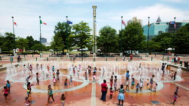 ARCHIVO - Foto del 22 de julio del 2016, personas caminan sobre fuentes en forma de los aros olímpicos en el Parque Olímpico Centenario en Atlanta. (AP Foto/David Goldman, Archivo)