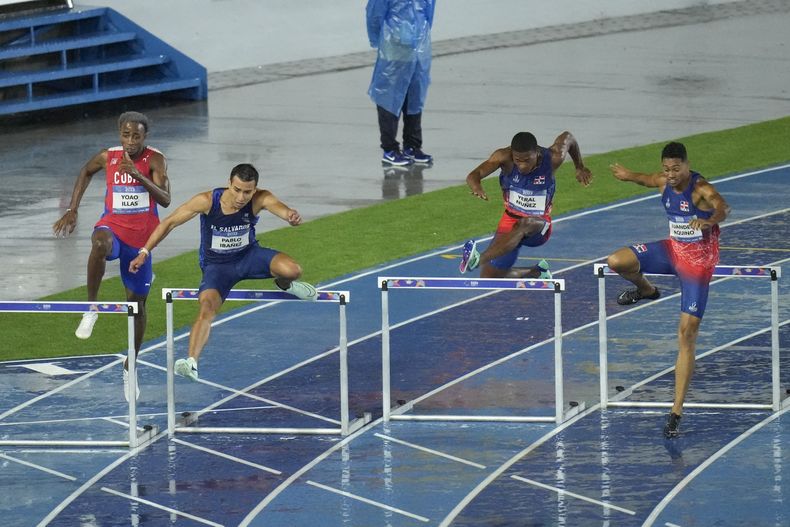 El salvadoreño Pablo Ibáñez (2do de izquierda a derecha) compite en los 400 metros con vallas el martes 4 de julio de 2023, en San Salvador (AP Foto/Arnulfo Franco)
