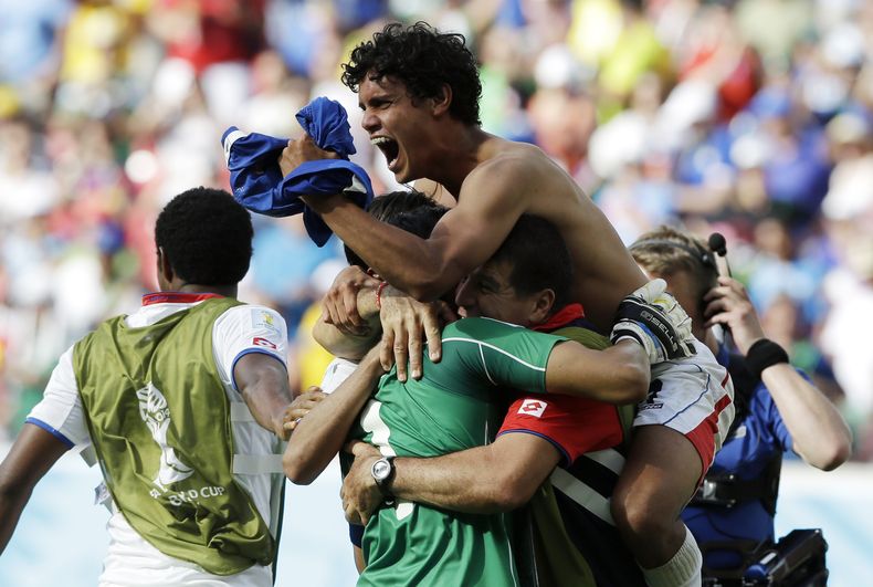 Los jugadores de Costa Rica festejan con el arquero Keylor Navas, centro de verde, tras vencer 1-0 a Italia y avanzar a los octavos de final del Mundial el viernes, 20 de junio de 2014, en Recife, Brasil.  (AP Photo/Ricardo Mazalan)