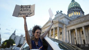 Una mujer se asoma por la ventana de un vehículo sosteniendo carteles de rechazo a la reforma económica promovida por el presidente argentino, Javier Milei, a su paso por el Congreso en Buenos Aires, Argentina, el martes 6 de febrero de 2024. La Cámara de Diputados tiene en debate el proyecto de ley que incluye una variedad de medidas económicas, administrativas, penales y medioambientales. (AP Foto/Natacha Pisarenko)
