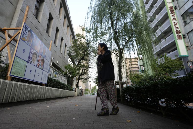 Una mujer mira un letrero con candidatos a las elecciones de la cámara baja del parlamento japonés en Tokio el 27 de octubre del 2024. (Foto AP/Hiro Komae)