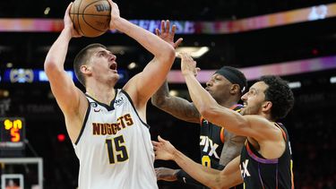 El serbio Nikola Jokic dispara por los Nuggets de Denver frente a Landry Shamet (derecha) y Torrey Craig, de los Suns de Phoenix, en el sexto duelo de la semifinal de la Conferencia Oeste, el jueves 11 de mayo de 2023 (AP Foto/Matt York)