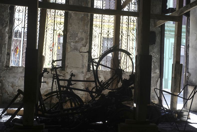 Una bicicleta quemada permanece en la sala de estar de la casa de una familia tras un incendio mortal en La Habana, Cuba, el martes 4 de julio de 2023. Una familia de siete personas, incluidos dos niños, murió el 28 de junio en el incendio que se originó por la explosión del motor de una bicicleta eléctrica, según la policía. (AP Foto/Ramón Espinosa)