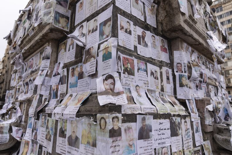 Retratos de personas desaparecidas que, según sus familiares, fueron capturadas por el régimen de Assad, alrededor de un monumento en Damasco, Siria, el sábado 28 de diciembre de 2024. (AP Foto/Mosaab Elshamy)