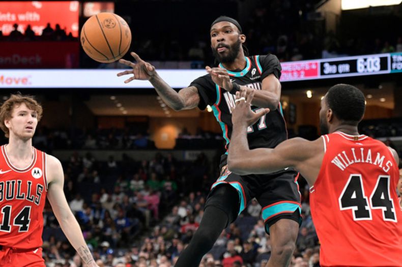 DeJon Jarreau, de los Grizzlies de Memphis, envía un pase entre Patrick Williams y Matas Buzelis, de los Bulls de Chicago, el sábado 28 de marzo de 2026 (AP Foto/Brandon Dill)