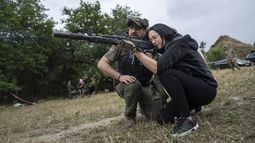 Una mujer dispara un AK-47 durante un entrenamiento táctico para civiles cerca de Zaporiyia, Ucrania, el domingo 9 de julio de 2023. (AP Foto/Evgeniy Maloletka)