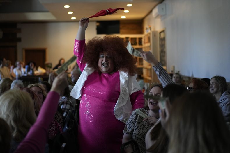 El público canta y sostiene propinas para la drag queen Alexus Daniels en Spring Fever Drag Brunch el 26 de marzo de 2023, en Kulpmont Winery en Kulpmont, Pensilvania. (Foto AP/Carolyn Kaster)