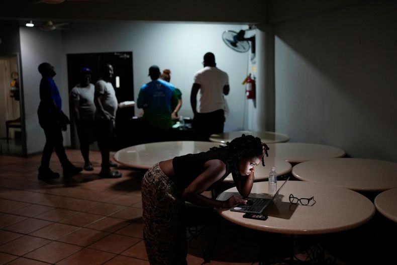 Una mujer hace una videollamada con una amiga antes de la llegada del huracán Melissa en Kingston, Jamaica, el lunes 27 de octubre de 2025. (AP Foto/Matias Delacroix)