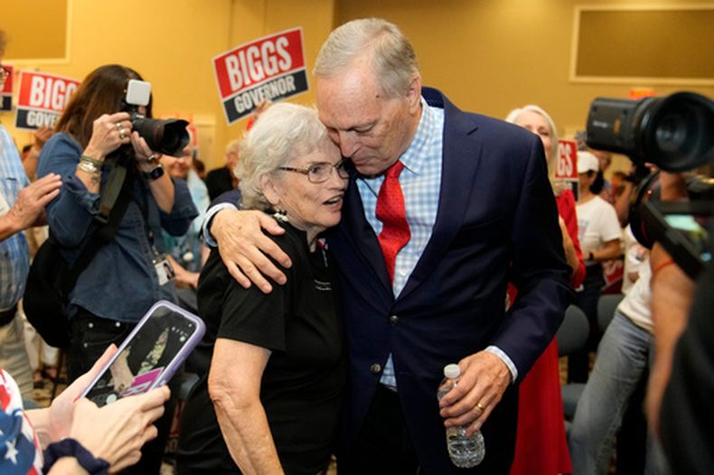 El representante por Arizona, Andy Biggs, derecha, que compite en las primarias para gobernadora de Arizona, abraza a una simpatizante en un evento de campaña, el viernes 17 de julio de 2026, en Gilbert, Arizona. (AP Foto/Ross D. Franklin)