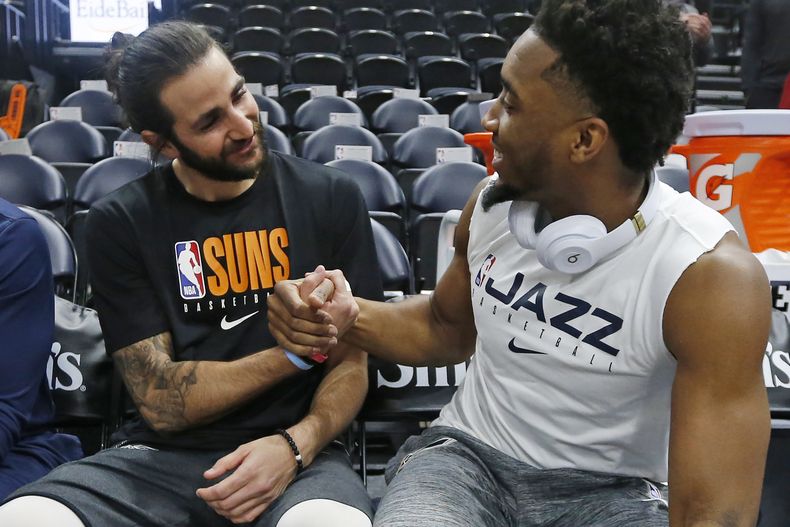ARCHIVO - El armador de los Suns de Phoenix Ricky Rubio (izquierda) y el armador del Jazz de Utah Donovan Mitchell conversan antes del juego de baloncesto de la NBA el lunes 24 de febrero de 2020, en Salt Lake City. (AP Foto/Rick Bowmer, archivo)