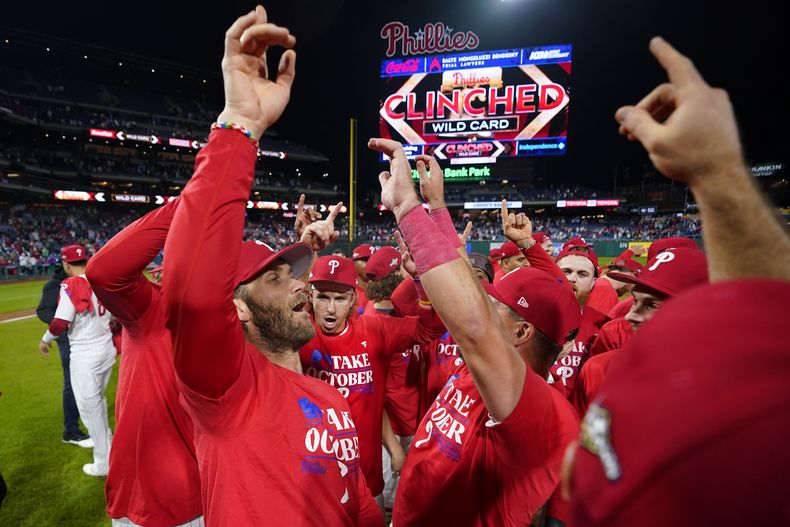 Bryce Harper, de los Filis de Filadelfia, festeja con sus compañeros tras clasificarse a la postemporada con un triunfo sobre los Piratas de Pittsburgh en el juego del martes 26 de septiembre de 2023 (AP Foto/Matt Slocum)
