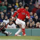 El dominicano Enmanuel Valdez, de los Medias Rojas de Boston, conecta un sencillo de dos carreras, adelante del cátcher mexicano Alejandro Kirk, de los Azulejos de Toronto, el miércoles 3 de mayo de 2023 (AP Foto/Michael Dwyer)