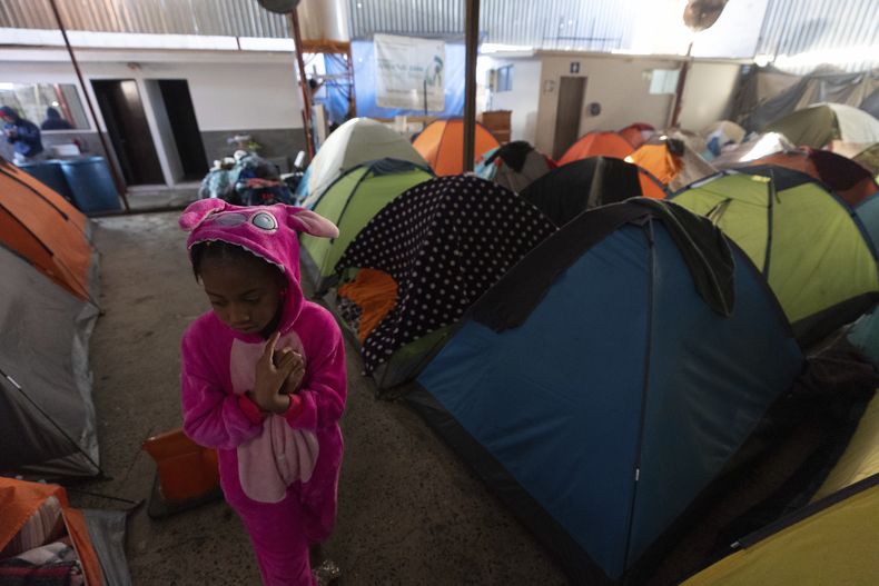 Maickeliys Rodríguez, de 6 años, de Venezuela, sale de su tienda en un refugio de migrantes en una mañana fría en Tijuana, México, el sábado 1 de febrero de 2025. (AP Foto/Gregory Bull)