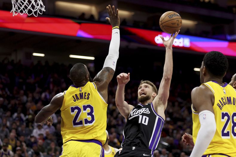Domantas Sabonis (10), de los Kings de Sacramento, toma un disparo ante la presión de LeBron James (23), de los Lakers de Los Ángeles, durante la segunda mitad del juego de baloncesto de la NBA, en Sacramento, California, el miércoles 3 de marzo de 2024. (AP Foto/Jed Jacobsohn)