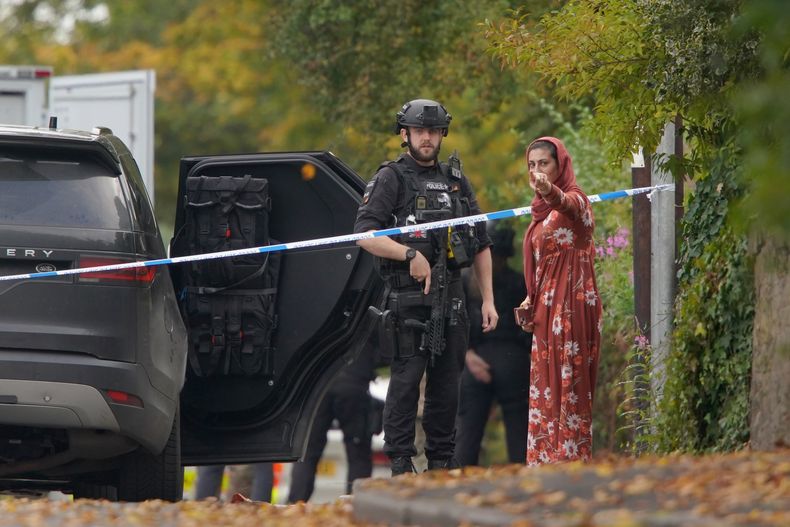 ARCHIVO - Un policía habla con una mujer cerca del lugar donde ocurrió un apuñalamiento en la sinagoga de la Congregación Hebrea de Heaton Park, en Crumpsall, Manchester, Inglaterra, el 2 de octubre de 2025. (Foto AP/Ian Hodgson, archivo)