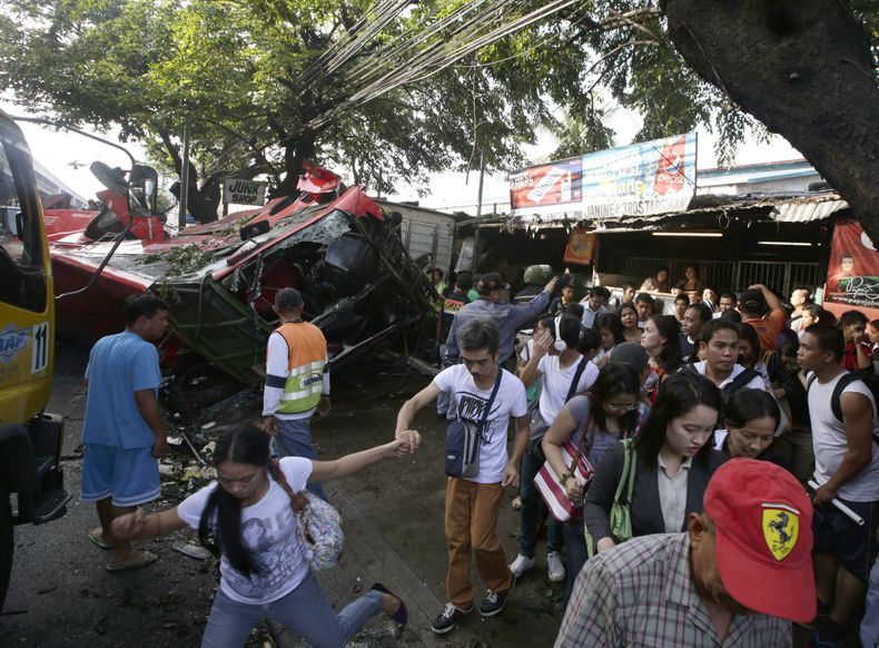 Vista de los restos de un autob&uacute;s de pasajeros que se precipit&oacute; desde una carretera elevada para incrustarse en una camioneta que pasaba por debajo en el suburbio de Paranaque, cerca de Manila, Filipinas, el lunes 16 de diciembre del 2013. E