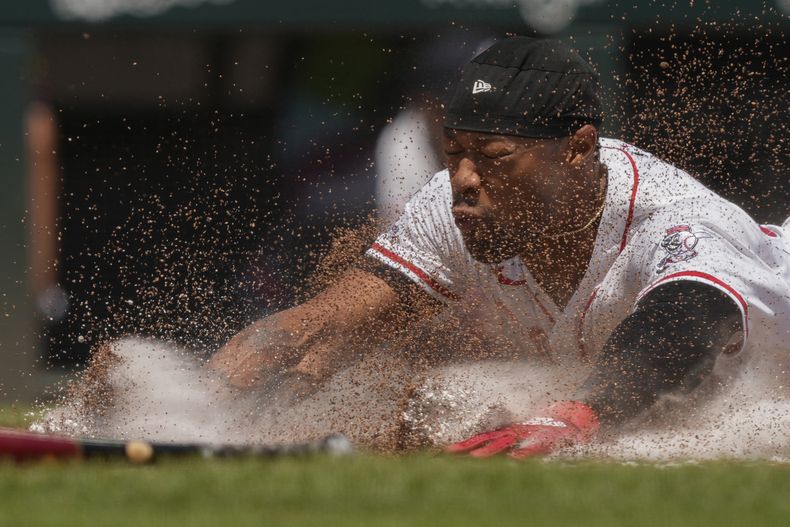 Will Benson de los Rojos de Cincinnati se desliza a salvo a home para anotar con un sencillo de Matt McLain durante la sexta entrada de un partido de béisbol contra los Bravos de Atlanta, el viernes 1 de agosto de 2025, en Cincinnati. (AP Photo/Carolyn Kaster)