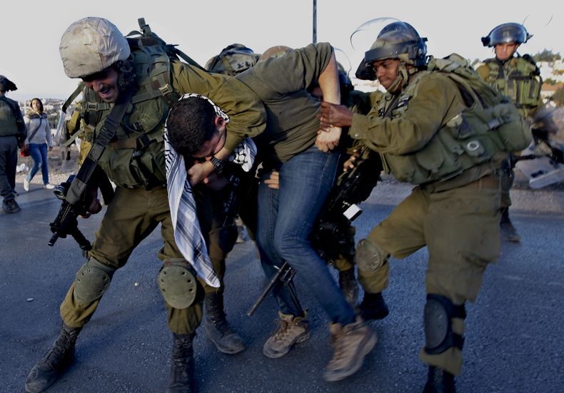 Polic&iacute;as israel&iacute;es detienen a un activista palestino durante una protesta por el proyecto de reasentar a la minor&iacute;a de beduinos palestinos de sus pueblos en el desierto del Negev, cerca del asentamiento jud&iacute;o de Bet El, al nort