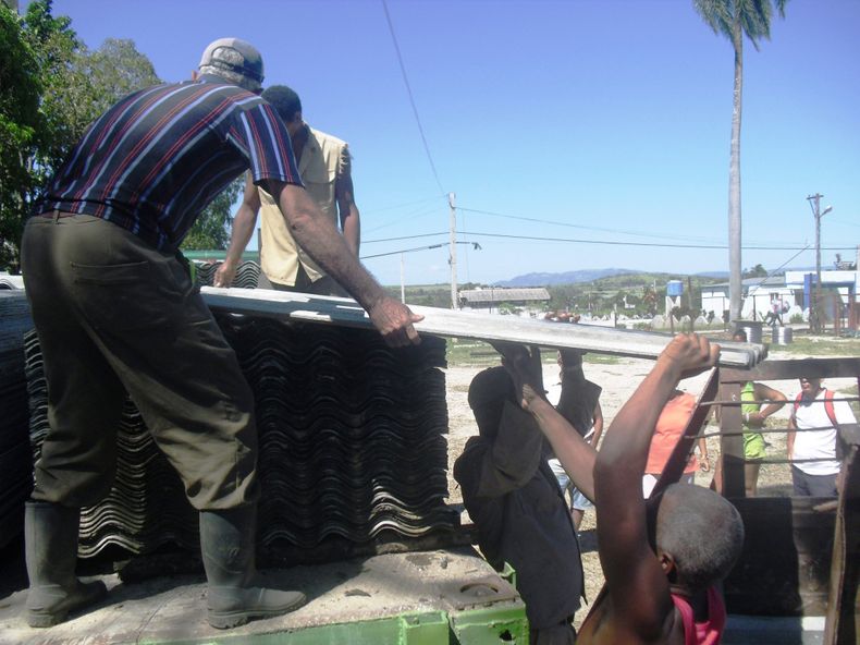 Damnificados por el paso del huracán Sandy reciben tejas para techar sus viviendas.