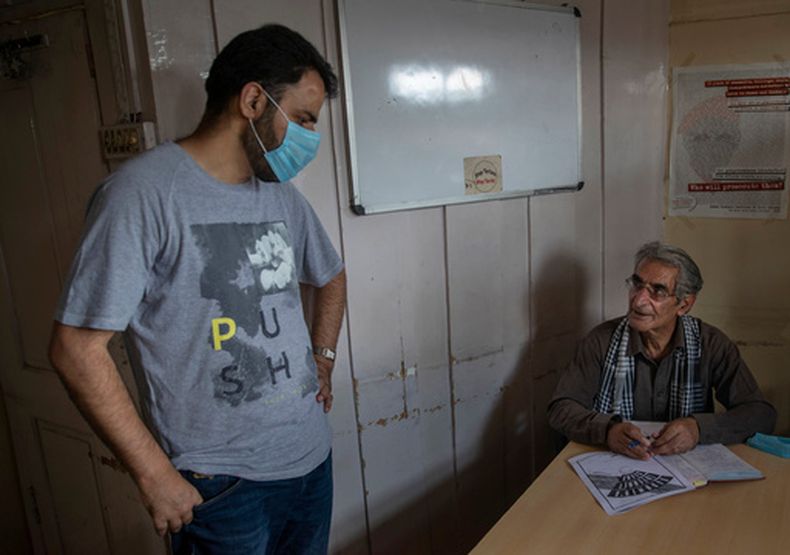 ARCHIVO - Khurram Parvez, izquierda, un destacado activista de derechos humanos, conversa con el abogado de derechos humanos Parvez Imroz en la oficina de la Coalición de la Sociedad Civil de Jammu y Cachemira, en Srinagar, en la Cachemira bajo control indio, el 25 de agosto de 2020. (Foto AP/Dar Yasin, archivo)