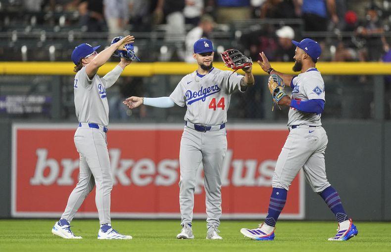 Desde la izquierda, Kiké Hernández, jardinero izquierdo; Andy Pagés, jardinero central; y Teoscar Hernández, jardinero derecho, celebran después de derrotar a los Rockies de Colorado en el juego de béisbol de Grandes Ligas, el martes 24 de junio de 2025, en Denver. (AP Photo/David Zalubowski)
