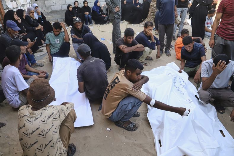 Familiares de palestinos asesinados en un centro de distribución de ayuda de la Fundación Humanitaria de Gaza, una organización respaldada por Estados Unidos y aprobada por Israel, lloran frente a sus cuerpos durante su funeral en el Hospital Nasser de Jan Yunis, en el sur de la Franja de Gaza, el sábado 19 de julio de 2025. (AP Foto/Mariam Dagga)