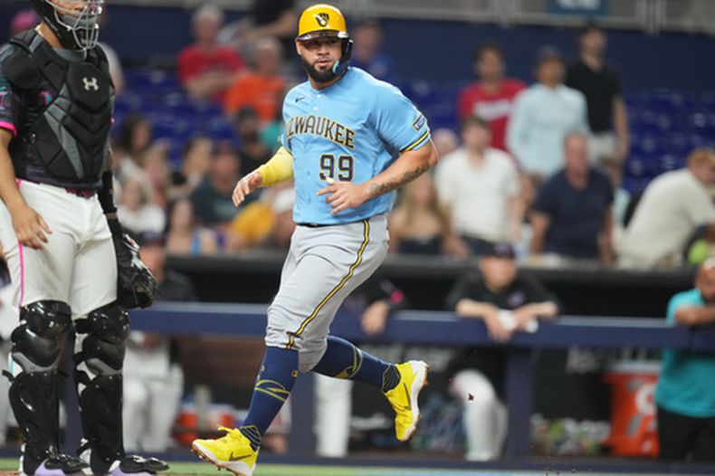 Gary Sánchez (99), de los Cerveceros de Milwaukee, anota con un sencillo de Garrett Mitchell durante la cuarta entrada del juego de béisbol de Grandes Ligas contra los Marlins de Miami, el viernes 17 de abril de 2026, en Miami. (AP Foto/Lynne Sladky)