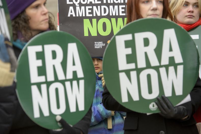 Una niña entre letreros de ERA NOW, en un mitin frente a los Archivos Nacionales para celebrar la decisión del presidente Joe Biden de declarar la Enmienda de Igualdad de Derechos (ERA, por sus siglas en inglés) como la 28.ª enmienda a la Constitución de Estados Unidos, el viernes 17 de enero de 2025, en Washington. (AP Foto/Rod Lamkey, Jr.)