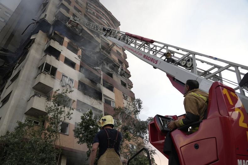 Un grupo de bomberos trabaja en el sitio de una explosión en un complejo residencial en el norte de Teherán, Irán, el viernes 13 de junio de 2025. (AP Foto/Vahid Salemi)