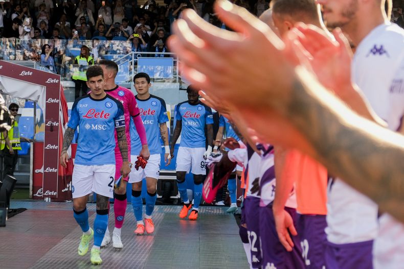 Los jugadores de Fiorentina (derecha) hacen un pasillo de honor a sus colegas de Napoli, flamantes campeones de la Serie A de Italia, el domingo 7 de mayo de 2023. (Alessandro Garofalo/LaPresse vía AP)