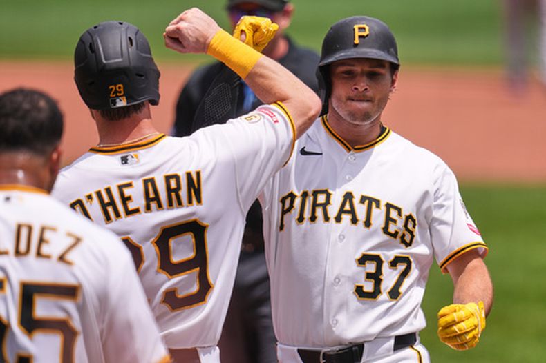 Tyler Callihan (37), de los Piratas de Pittsburgh, celebra con Ryan OHearn (29) mientras cruza el plato tras conectar un jonrón de tres carreras ante el lanzador de los Rojos de Cincinnati, Brady Singer, durante la segunda entrada de un partido de béisbol en Pittsburgh, el domingo 28 de junio de 2026. (Foto AP/Gene J. Puskar)