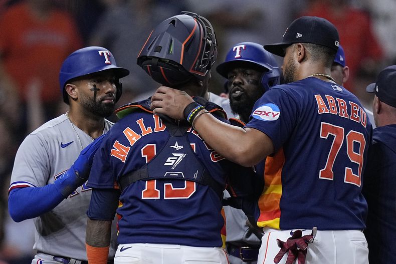 El puertorriqueño Martín Maldonado, de los Astros de Houston, y el cubano Adolis García (derecha), de los Rangers de Texas, discuten en el juego del miércoles 26 de julio de 2023 (AP Foto/Kevin M. Cox)