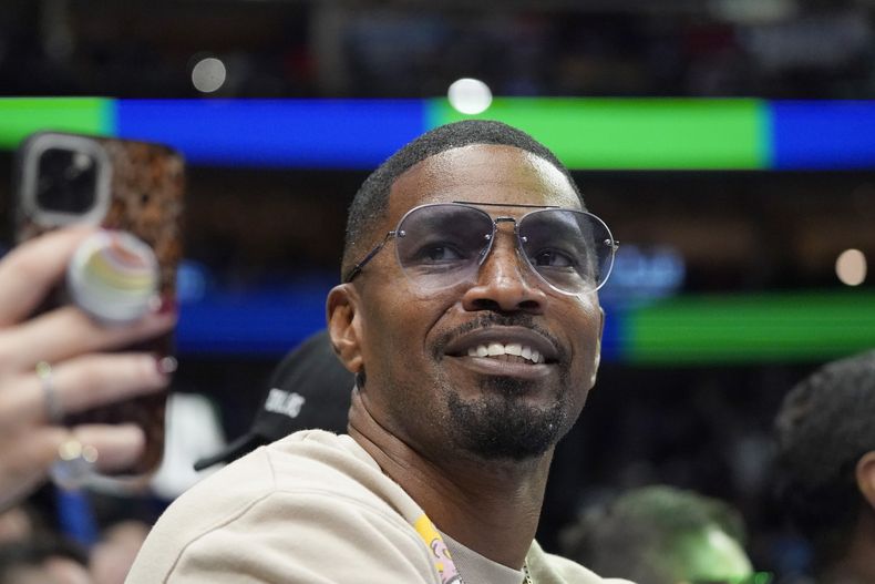 ARCHIVO - El actor Jamie Foxx sonríe durante un partido de la NBA entre los Wizards de Washington y los Mavericks, en Dallas, el sábado 27 de noviembre de 2021. (AP Foto/LM Otero, archivo)
