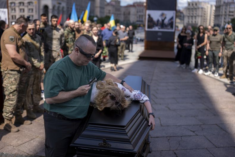 La pareja del médico británico de combate y voluntario Peter Fouche, de 49 años, que murió el 27 de junio cuando trabajaba en el este de Ucrania, llora durante el funeral en la plaza principal de la ciudad en Kiev, Ucrania, el sábado 6 de julio de 2024. Peter era el fundador de una organización benéfica que proporcionada vehículos, drones y otros materiales a soldados ucranianos. (AP Foto/Alex Babenko)