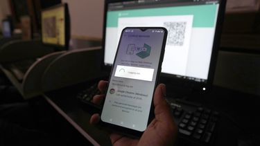ARCHIVO -Un pakistaní espera conectar su versión móvil de WhatsApp a una computadora de escritorio con una lenta conexión a Internet que se mantuvo por varios días, en Karachi, Pakistán, el 19 de agosto de 2024. (AP Foto/Fareed Khan, Archivo)