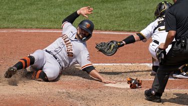 J.D. Davis de los Gigantes de San Francisco se desliza para anotar una carrera ante los Piratas de Pittsburgh, el domingo 16 de julio de 2023. (AP Foto/Gene J. Puskar)